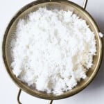 White rice in a gold dish on a white background.