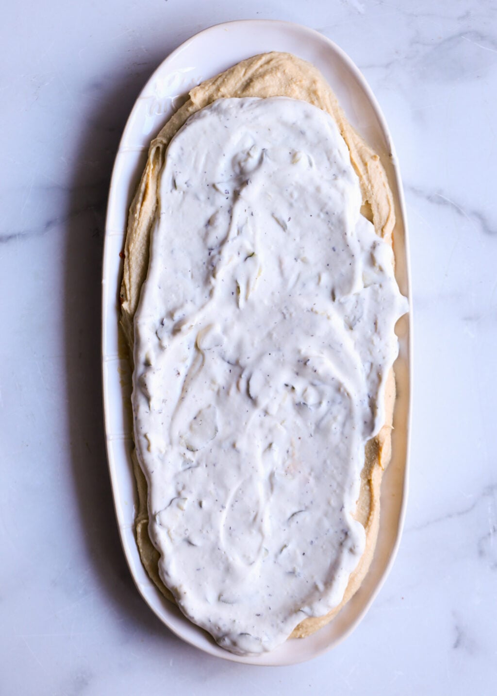 Easy layered Greek dip with creamy hummus and tzatziki, a healthy Mediterranean appetizer perfect for parties or dinner.
