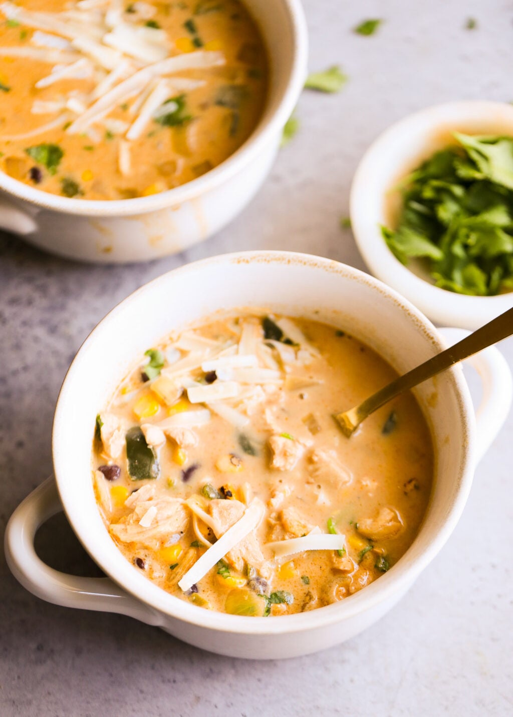 Easy creamy chicken poblano soup for dinner, with corn, peppers, and shredded cheese