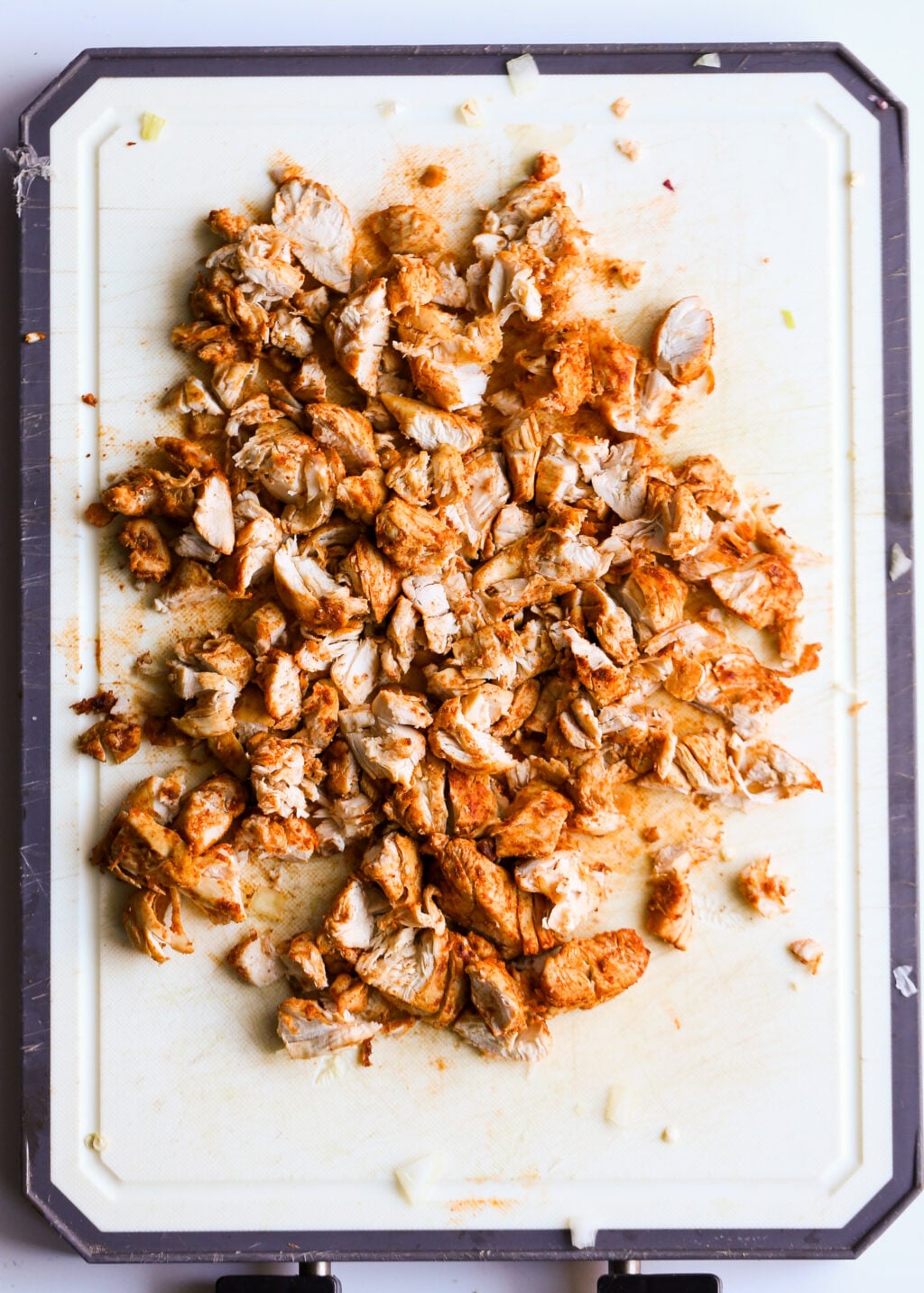 Easy chopped chicken on cutting board, seasoned and ready for creamy chicken poblano soup dinner.