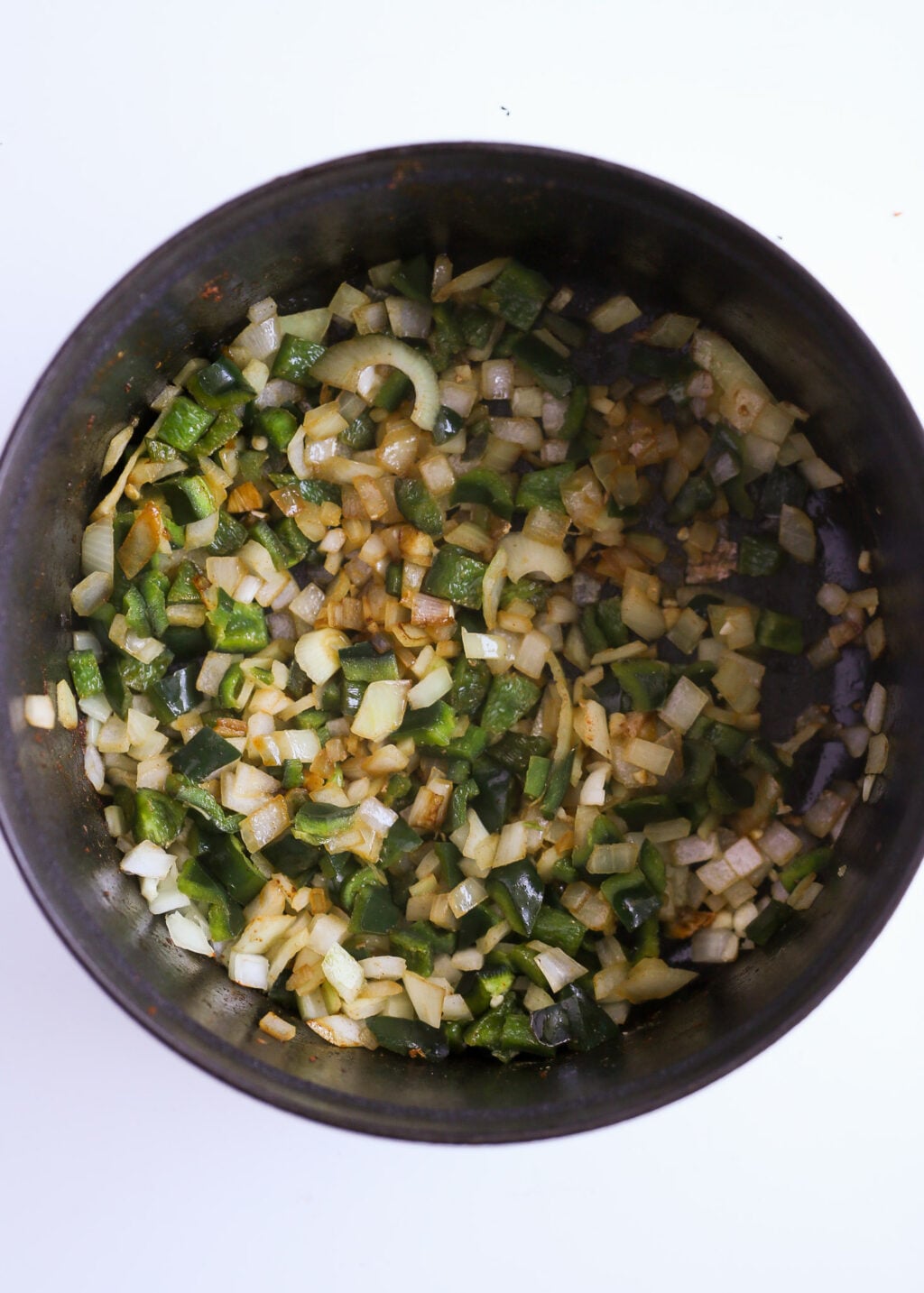 Diced onion and poblano peppers sautéed in a pot, forming the base for easy creamy chicken poblano soup.