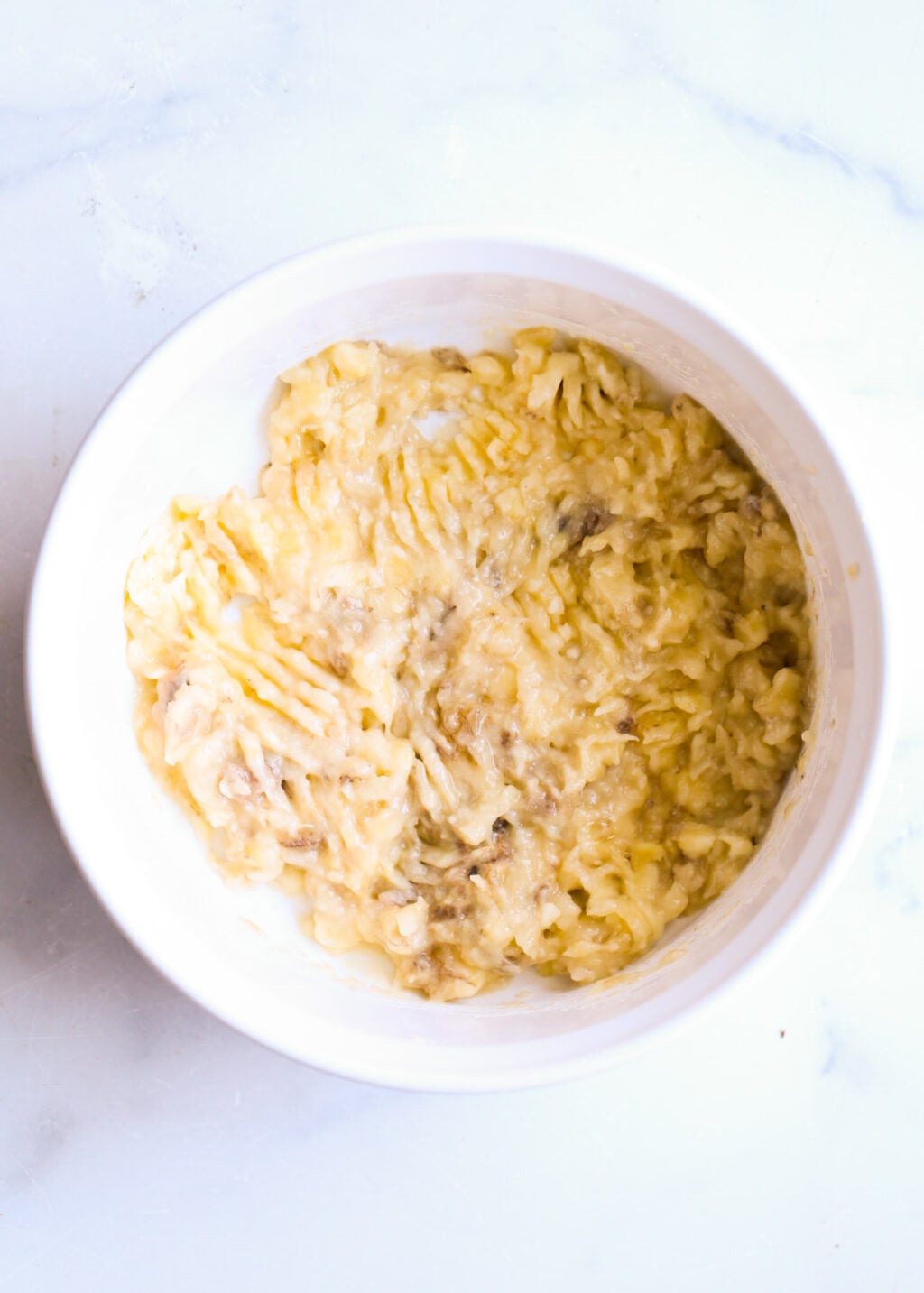 Easy high-protein peanut butter banana bread batter in a white bowl; creamy mashed banana texture.