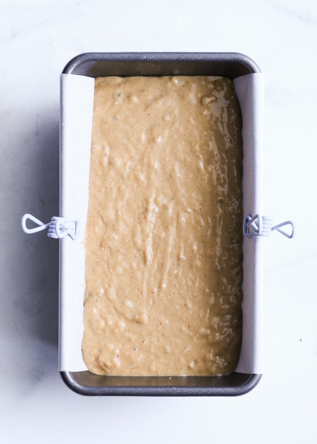 High-protein peanut butter banana bread batter in parchment-lined loaf pan—easy healthy banana bread recipe.