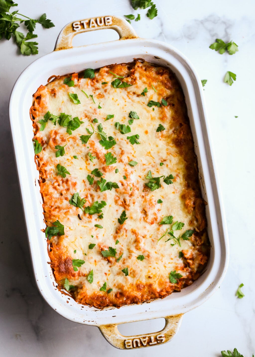 Cheesy unstuffed cabbage casserole baked in a Staub dish, garnished with fresh parsley – perfect dinner recipe