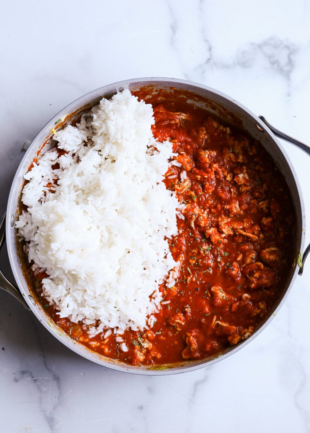 Unstuffed cabbage casserole with ground beef in tomato sauce, served over fluffy white rice. Easy dinner recipe.