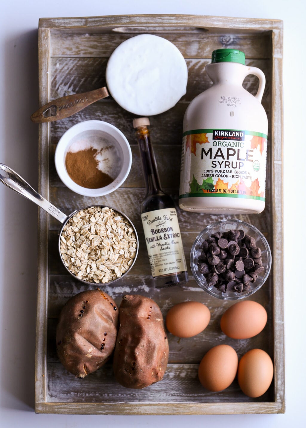 Sweet potato chocolate chip breakfast casserole ingredients: oats, maple syrup, eggs, vanilla, cinnamon, and chocolate chips.