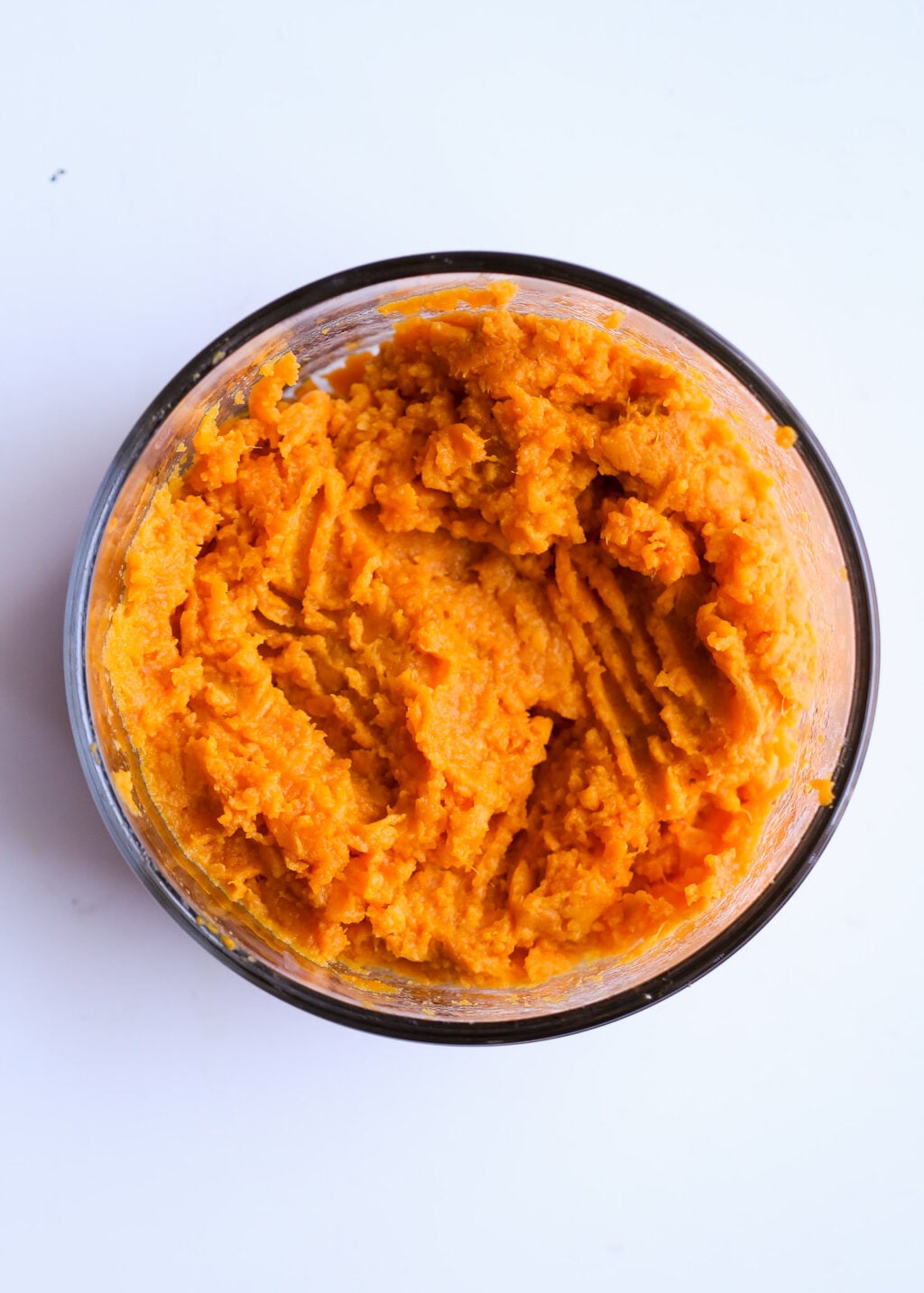 Creamy sweet potato mash in a blender jar, a base for a high-protein sweet potato chocolate-chip breakfast casserole recipe.
