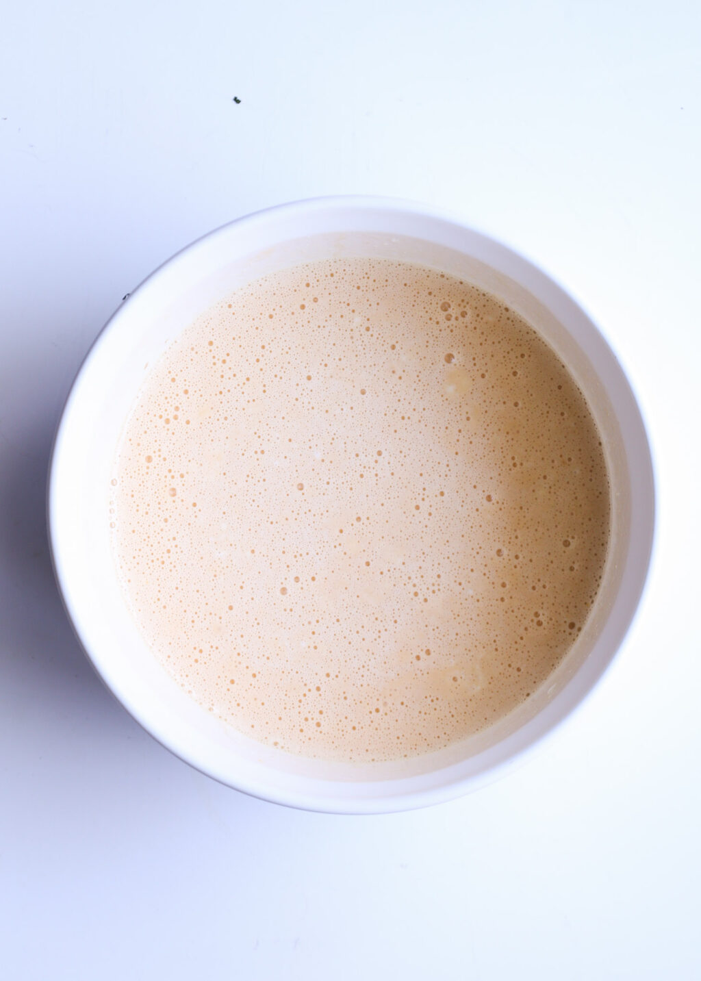 Top-down view of a creamy latte in a white cup; ideal for a sweet potato chocolate chip breakfast casserole recipe pin.