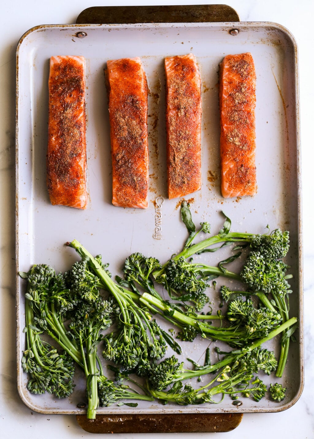 Sheet-pan blackened salmon fillets with broccolini on a baking sheet, an easy weeknight dinner.