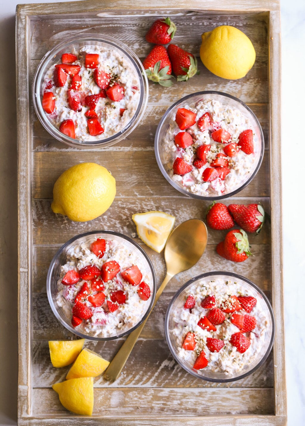 Strawberry lemon overnight oats topped with fresh strawberries in glass bowls—easy 5-minute breakfast meal-prep idea.