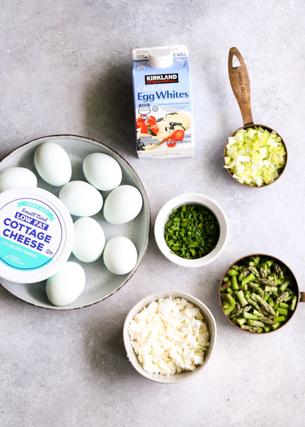 Egg muffins with asparagus and feta: eggs, cottage cheese, asparagus, feta, and green onions for a high-protein breakfast meal prep.