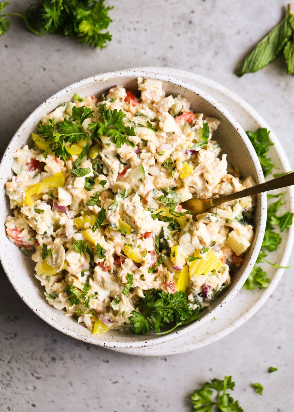 Creamy Mediterranean chicken salad with shredded chicken, mashed chickpeas, feta, peppers, artichokes, cucumber, mint and parsley.