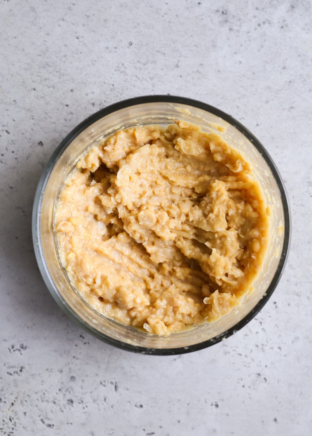 Creamy mashed chickpeas , pale beige texture, forming the base for a Mediterranean chicken salad.