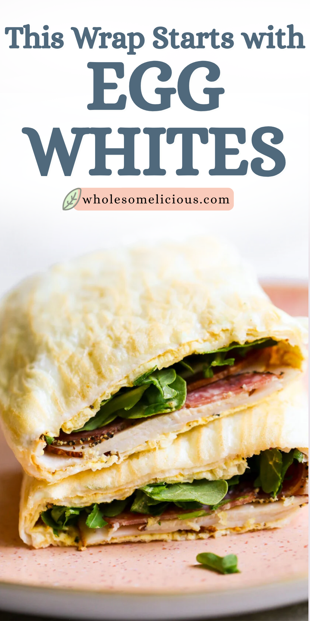 Egg‑white wrap folded around greens and sliced meat, served on a pink plate with scattered herbs.