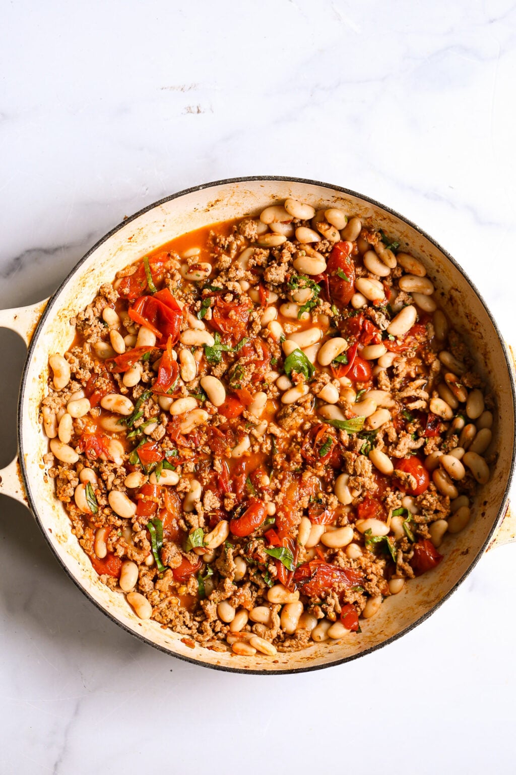 Ground turkey simmered with white beans, cherry tomatoes, basil, and cheese for a hearty one‑pan meal.